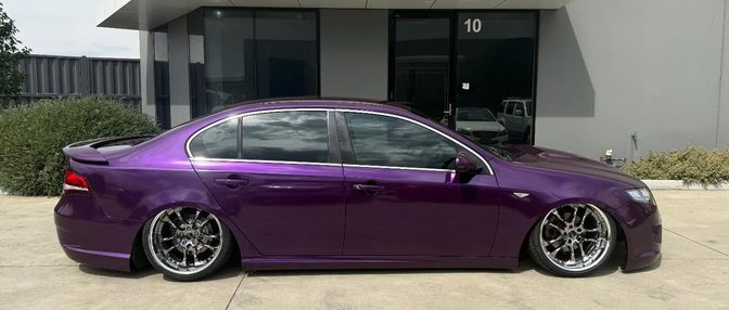 A lowered Ford Falcon in a purple colour change wrap outside the Cranbourne workshop